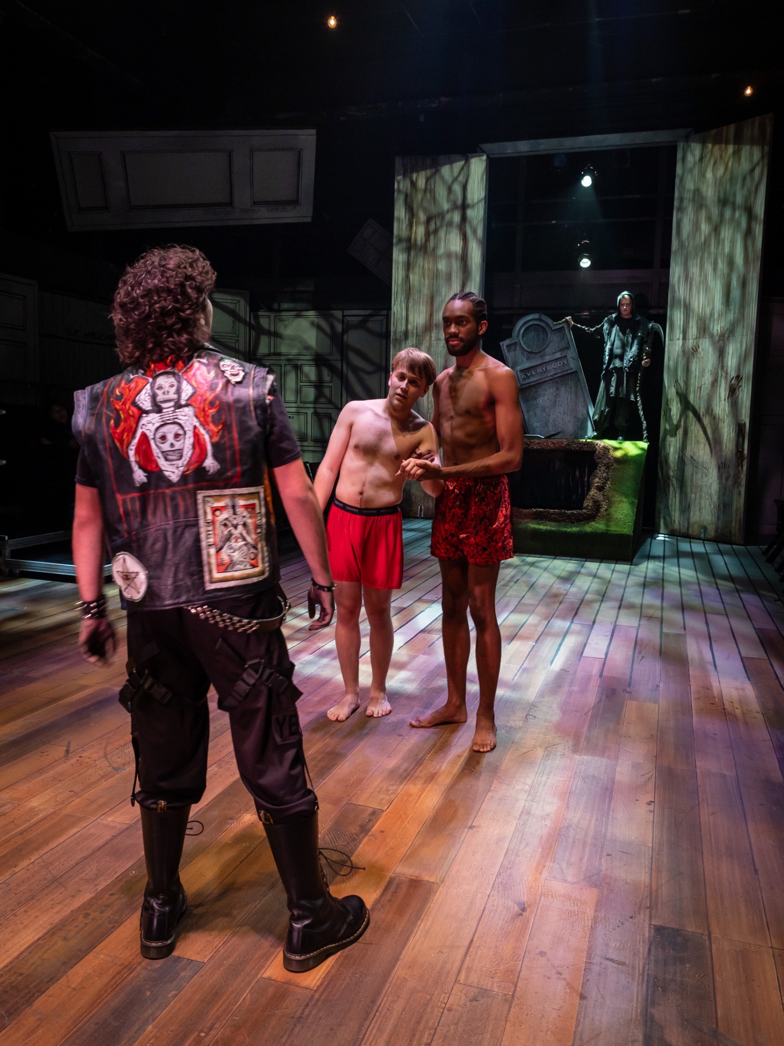 Performers approach a graveyard setting.